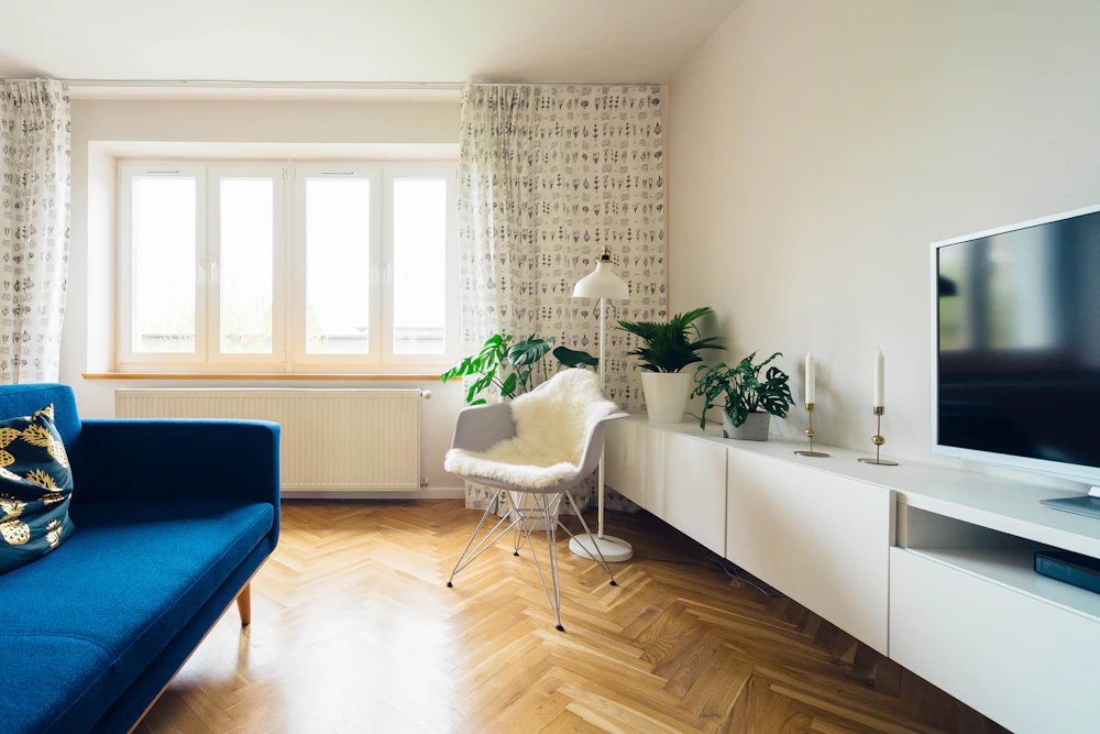 Ett ljust vardagsrum med fiskbensparkett i en bostadsrätt
